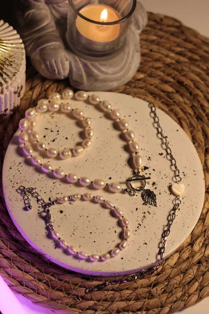Stylish pearl jewelry set artfully displayed with a candlelit ambiance.