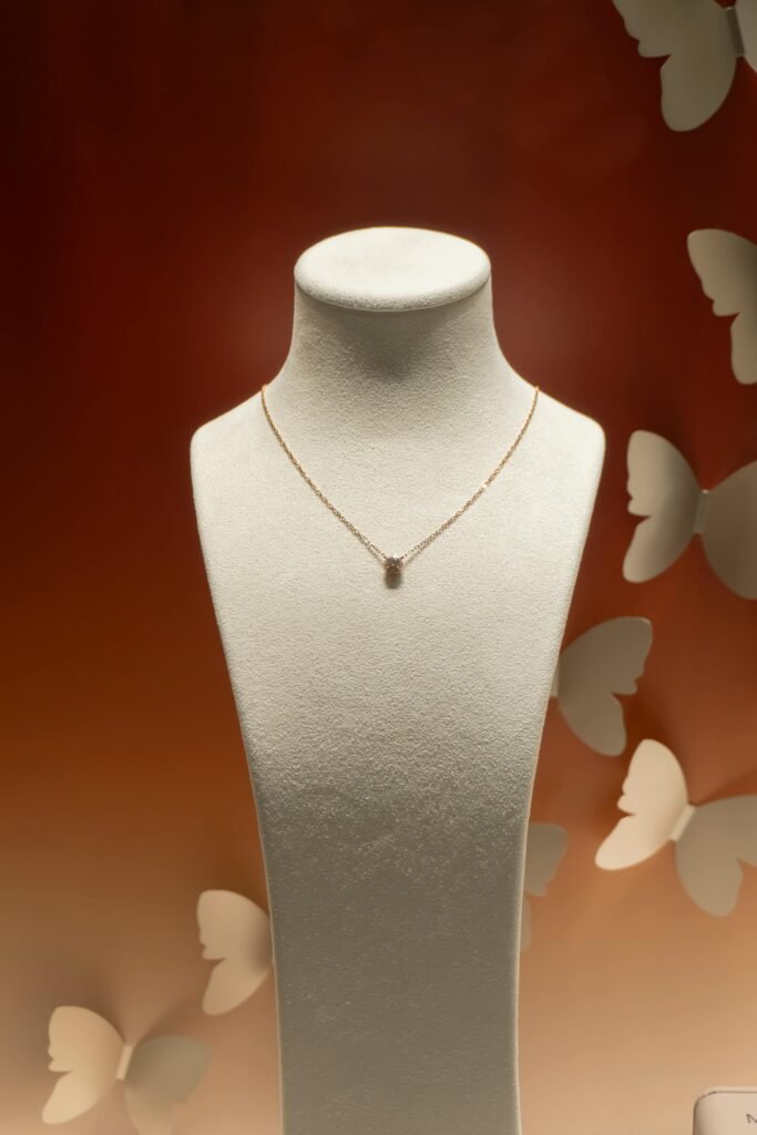 Showcase of a luxurious necklace on a mannequin with a butterfly-themed backdrop, perfect for a jewelry exhibition.